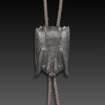 A bolo tie with three silver bats